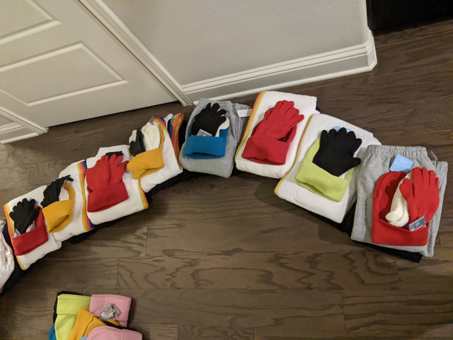 Care bundles with sweatshirts, gloves, and beanies arranged in a row